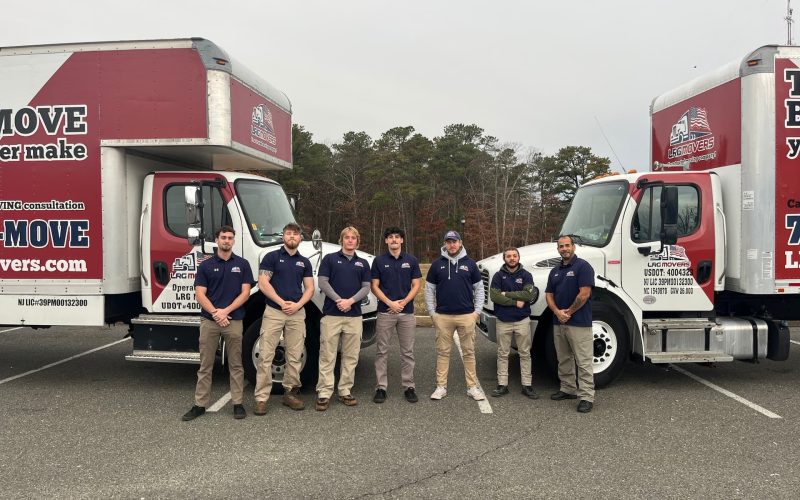 The LRG Movers team stood next to two removal trucks branding LRG Movers.